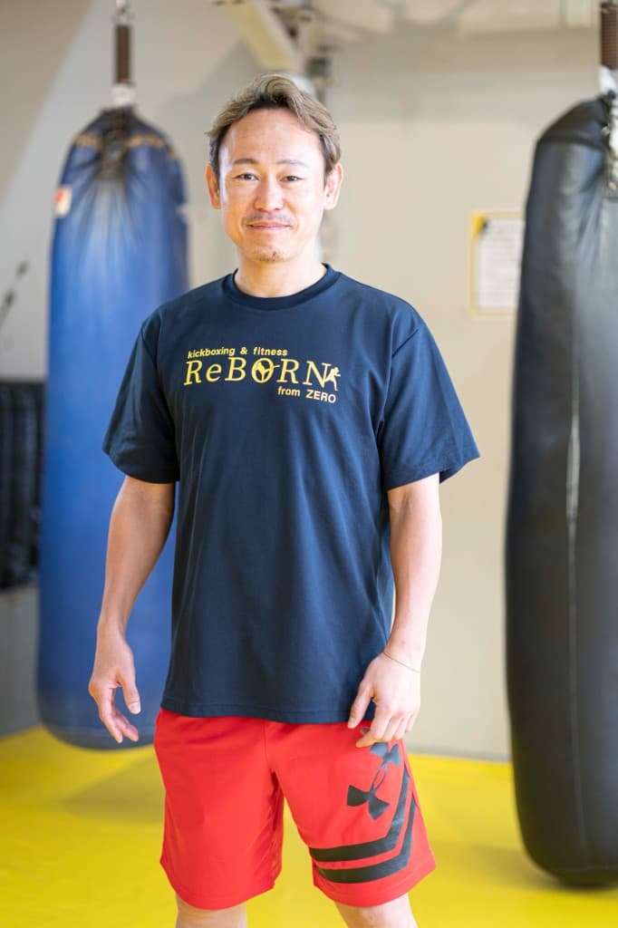 ジム内でサンドバッグの前に立つReBORN経堂の代表トレーナー